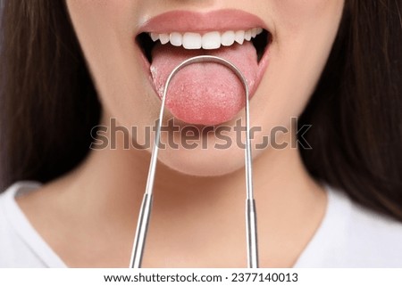Woman brushing her tongue with cleaner, closeup Royalty-Free Stock Photo #2377140013