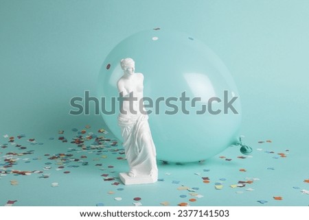 a venus in front of a balloon of the same color as the background. Confetti on the ground. color gradation. Minimalist, trendy still life photography.