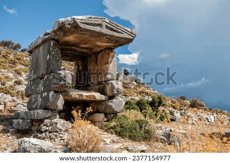 Ancient old ruined tombs on sunny day against cloudy sky in Turkey