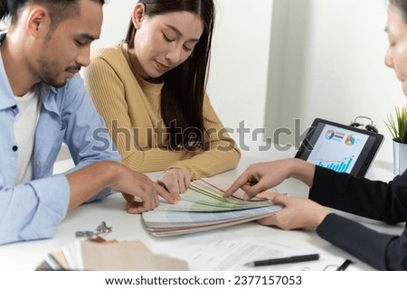 Real estate sales agent explain rental or buying condition to young couple before move to new home or apartment at real estate sales office. Asian urban lifestyle or real estate business concept.
