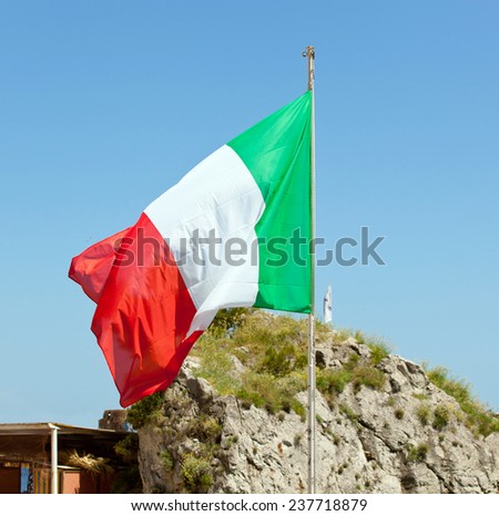 Italian flag waving on the wind over natural background.