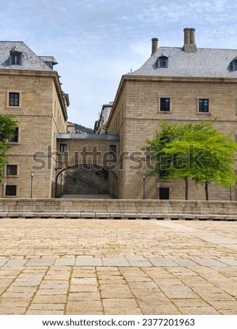 San Lorenzo del Escorial in Madrid Province in a sunny day. Its ancient palace with gardens and flowers