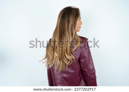 The back side view of a Young beautiful woman. Studio Shoot.