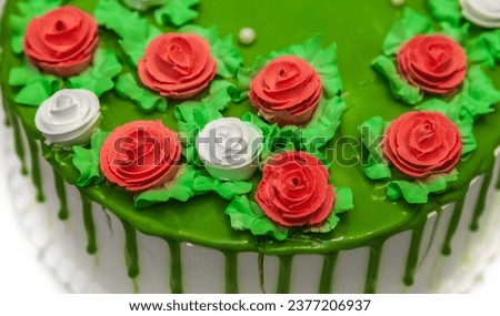 Part of the anniversary cake decorated with white and red cream roses close-up on a white background