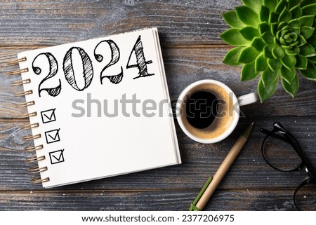 New year resolutions 2024 on desk. 2024 resolutions list with notebook, coffee cup on table. Goals, resolutions, plan, action, checklist concept. New Year 2024 template, copy space Royalty-Free Stock Photo #2377206975