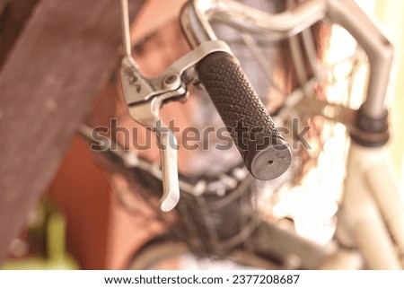 A close-up shot of a bicycle handlebar against a blurred background