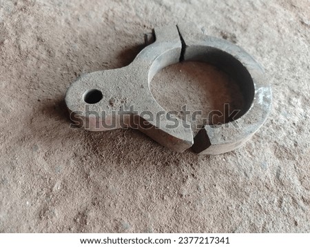 Top view of vintage rusty 316L metal iron ferrule tri-clamp on the ground. Rusty Tri-Clamp Ferrule on a white background Royalty-Free Stock Photo #2377217341