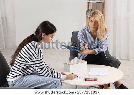 Psychologist working with teenage girl in office. Teenager problems