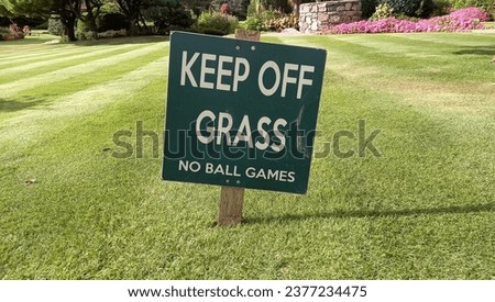 Keep Off Grass sign in striped lawn