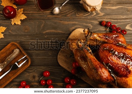 roasted turkey near honey and maple syrup on wooden table with autumnal decor, thanksgiving