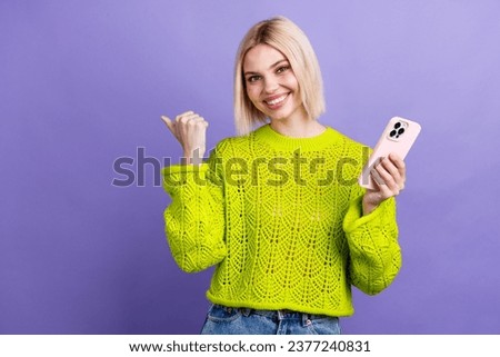 Photo of adorable cute woman dressed knitted sweater typing modern device thumb empty space isolated violet color background