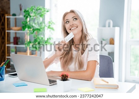 Photo of minded thiughtful lovely girl sitting in comfortm house room day holding bank card online shopping