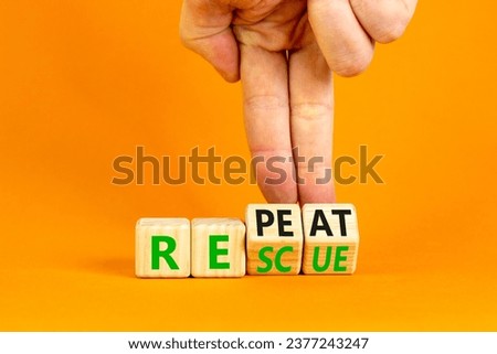 Rescue and repeat symbol. Concept words Rescue Repeat on wooden block. Beautiful orange table orange background. Businessman hand. Business rescue and repeat concept. Copy space.
