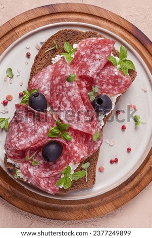 Sandwich , grain bread, with cream cheese and salami, black olives, micro-greens, top view, close-up, no people, Breakfast, Royalty-Free Stock Photo #2377249899