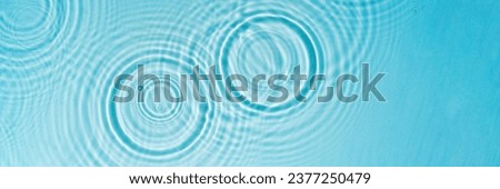 Patterns from Circles from drops on clear water Transparent blue water surface with ripples. Cosmetic moisturizing essence Banner