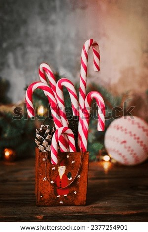 candy canes and Christmas decoration on wooden table. vertically