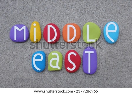 Middle East, is a geopolitical region encompassing the Arabian Peninsula, the Levant, Turkey, Egypt, Iran, and Iraq, souvenir composed with multi colored stone letters over beach sand Royalty-Free Stock Photo #2377286965