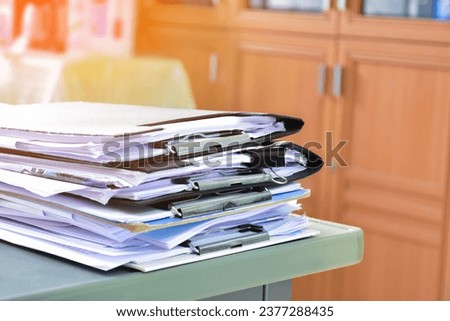 Stack of documents on table of secretary, sunlight edited, soft and selective focus.