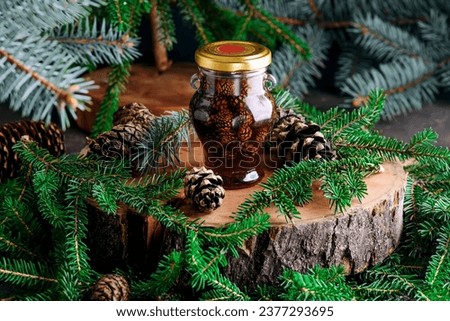 Jam from young pine cones in syrup on a background with pine branches.style rustic.selective focus Royalty-Free Stock Photo #2377293695