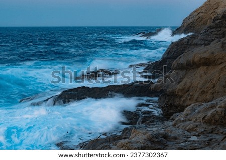 Long exposure photography of waves in motion hitting the rocks of the Ikarian coast