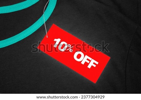 Red tag on a grey and green t-shirt with "10% off" written in white.