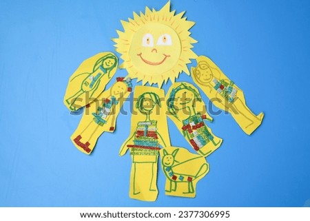 applique made of colored paper sun and children on a blue background