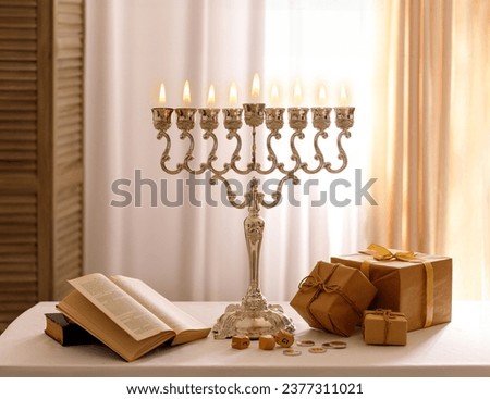Jewish religious holiday Hanukkah with holiday Hanukkah (traditional candelabra), tallit, gift boxes, wooden dreidels (spinning top), chocolate coins on wood background