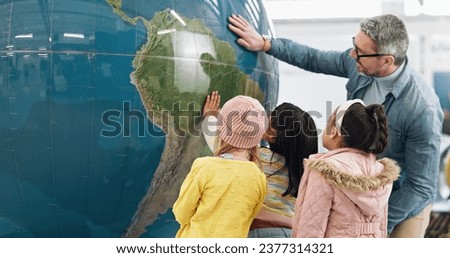 Science, world and students learning about the earth with a teacher at school for growth or development. Geography, globe or planet with a man teaching kids about climate change or global warming Royalty-Free Stock Photo #2377314321