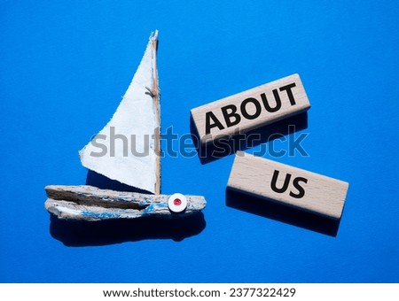 About us symbol. Concept word About us on wooden blocks. Beautiful blue background with boat. Business and About us concept. Copy space