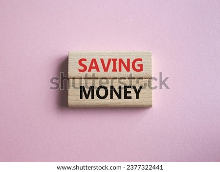 Saving Money symbol. Concept word Saving Money on wooden blocks. Beautiful pink background. Business and Saving Money concept. Copy space