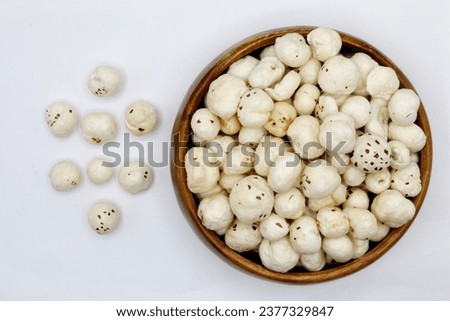 Crispy Lotus pops Seeds or Phool Makhana in wooden bowl top view isolated on white background
