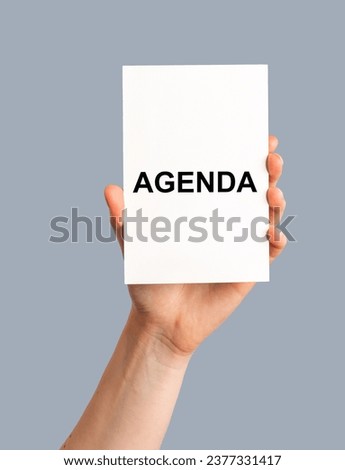 Agenda word on paper card in hand