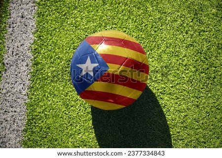 football ball with the national flag of catalonia on the green field near the white line