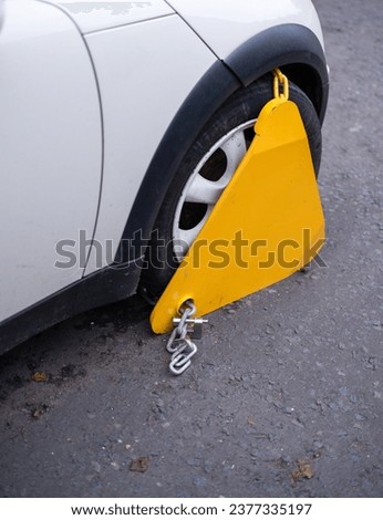 A Car In The Street With A Clamp (Or Denver Boot) On Its Wheel After Being Parked Illegally (With Copy Space) Royalty-Free Stock Photo #2377335197