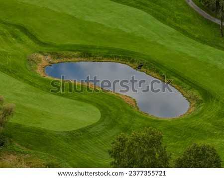 A high angle, aerial view over a well maintained and private golf course in Westchester, New York during a cloudy day. No one was playing golf.