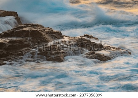 Long exposure photography of waves in motion hitting the rocks of the Ikarian coast