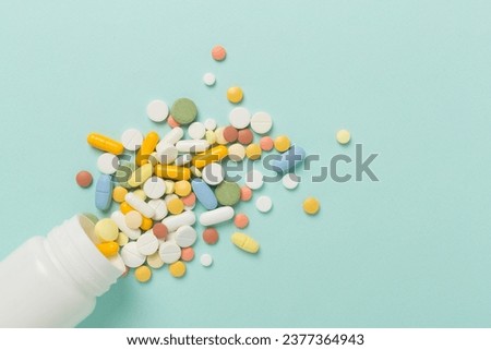 Jar with different medical pills and capsules on color background, top view Royalty-Free Stock Photo #2377364943