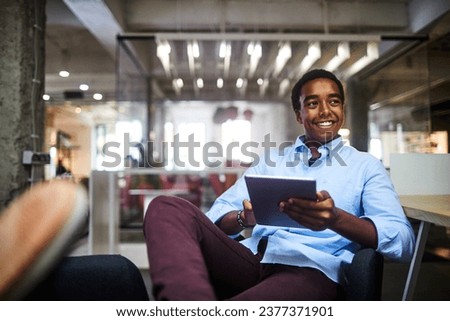 Successful young businessman using a tablet in a modern office Royalty-Free Stock Photo #2377371901