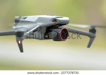 Drone quadcopter with digital camera and fast rotating propellers flying taking video and pictures