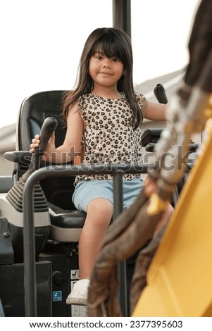 little girl pretend to play with mini excavator vehicles. we ask permission to take a picture for my daughter to the truck operator while he take his break time eating lunch 