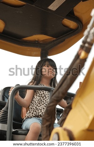 little girl pretend to play with mini excavator vehicles. we ask permission to take a picture for my daughter to the truck operator while he take his break during lunch 