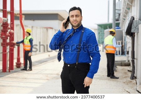 businessman talking on smartphone at construction site
