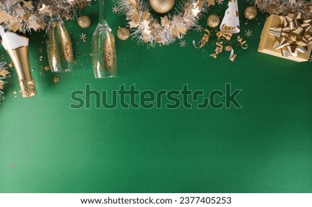 Happy New year celebration background concept. Champagne with glass, golden ribbon, stars and christmas ball on green background.