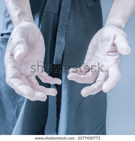 Hand showing gestures of the elderly and hand wrinkled. On a gray background