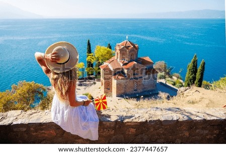 Macedonia- travel, tour tourism,vacation- Woman in white dress and macedonian flag enjoying Ohrid lake  Royalty-Free Stock Photo #2377447657