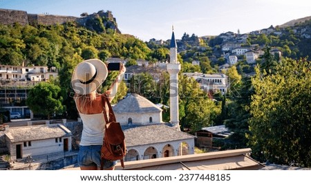 Woman tourist taking picture with smartphone of beautiful mosque in Gjirokaster city- Travel in Albania Royalty-Free Stock Photo #2377448185