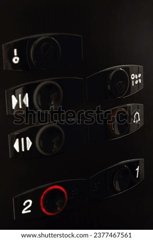 Round black buttons floors in the modern elevator. Shooting at an angle. Selective focus. Close-up. Copy space. 
