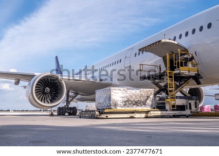 Air cargo logistic containers are loading to an airplane. Air transport shipment prepare for loading to modern freighter jet aircraft at the airport. Royalty-Free Stock Photo #2377477671