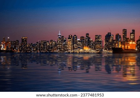 Vancouver skyline at night and reflections in harbor water. Downtown Vancouver.  British Columbia. Canada
