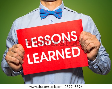 Man holding a card with the text Lessons learned on white background